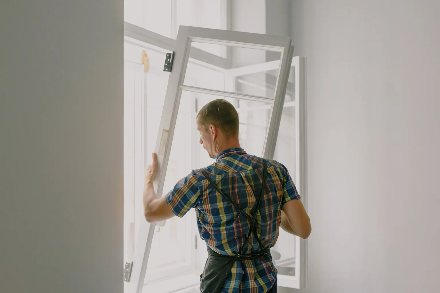 Professional installer carefully sealing and insulating around a new window frame - best windows for insulation Professional installer carefully sealing and insulating around a new window frame - best windows for insulation